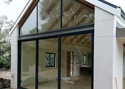 Black-framed sliding glass doors beneath a large triangular glazed gable
