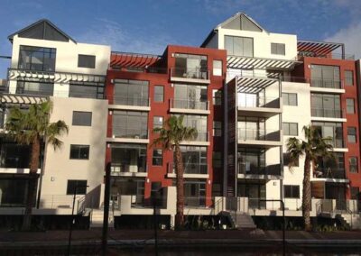 Multi-story residential building with glass balconies, large windows and modern façades